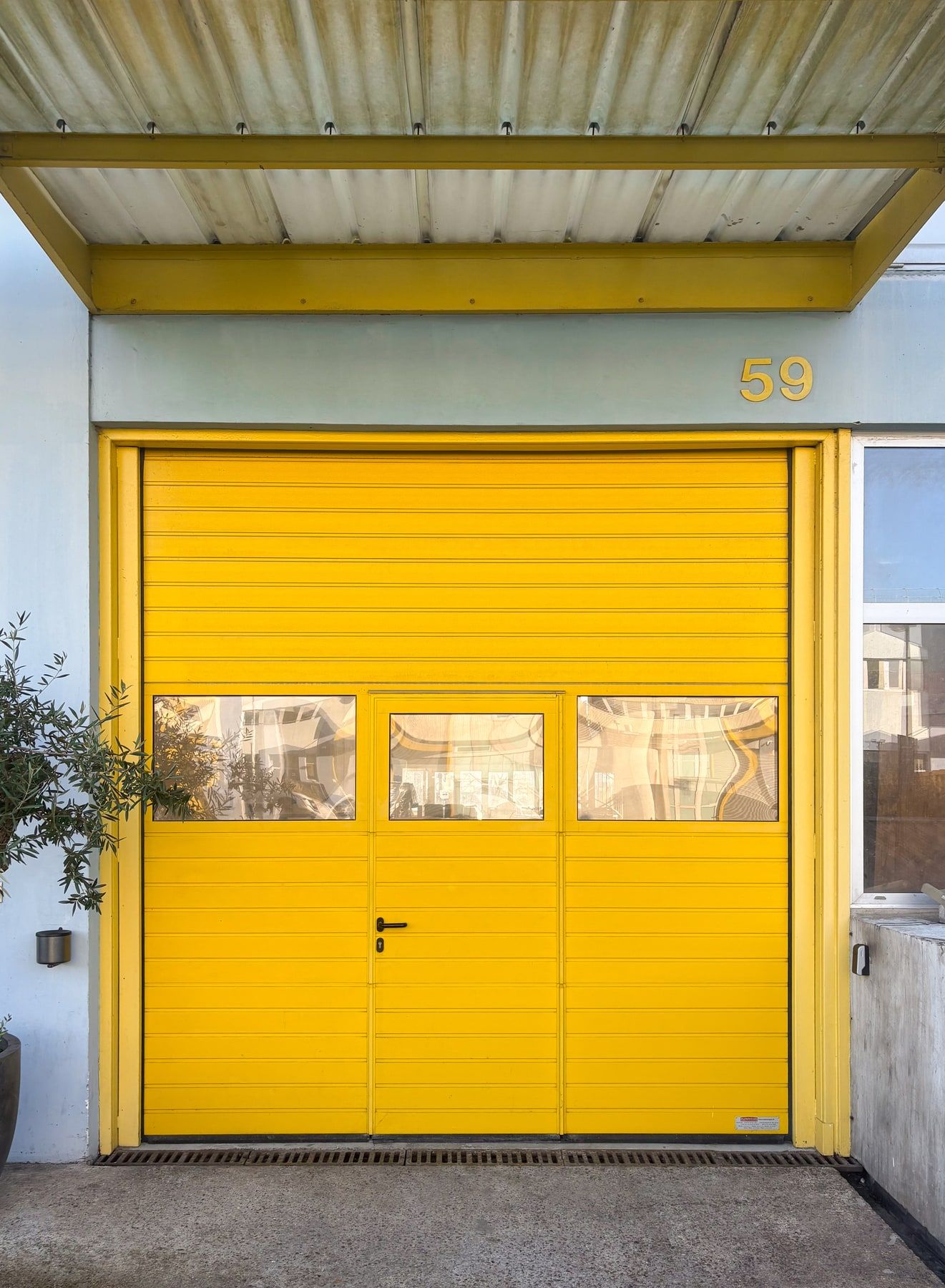La porte sectionnelle jaune du 59, rideau baissé, à l'entrée de l'entrepôt de Cap 18
